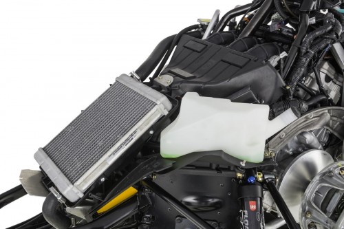 Front mounted large radiator controls engine coolant temperature in various snow conditions. A large volume air box feeds the engine for maximum horsepower.